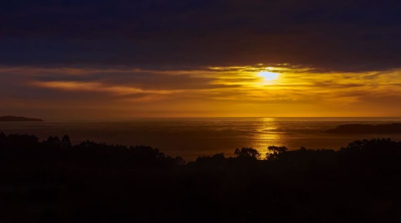 Atardece entre la costa y el horizonte