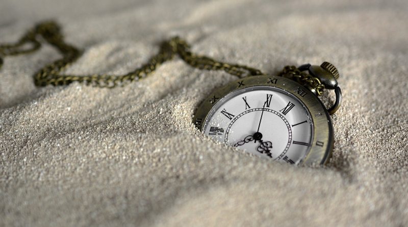 Reloj de mano semienterrado en la arena (Fuente: Pixabay.com - annca)